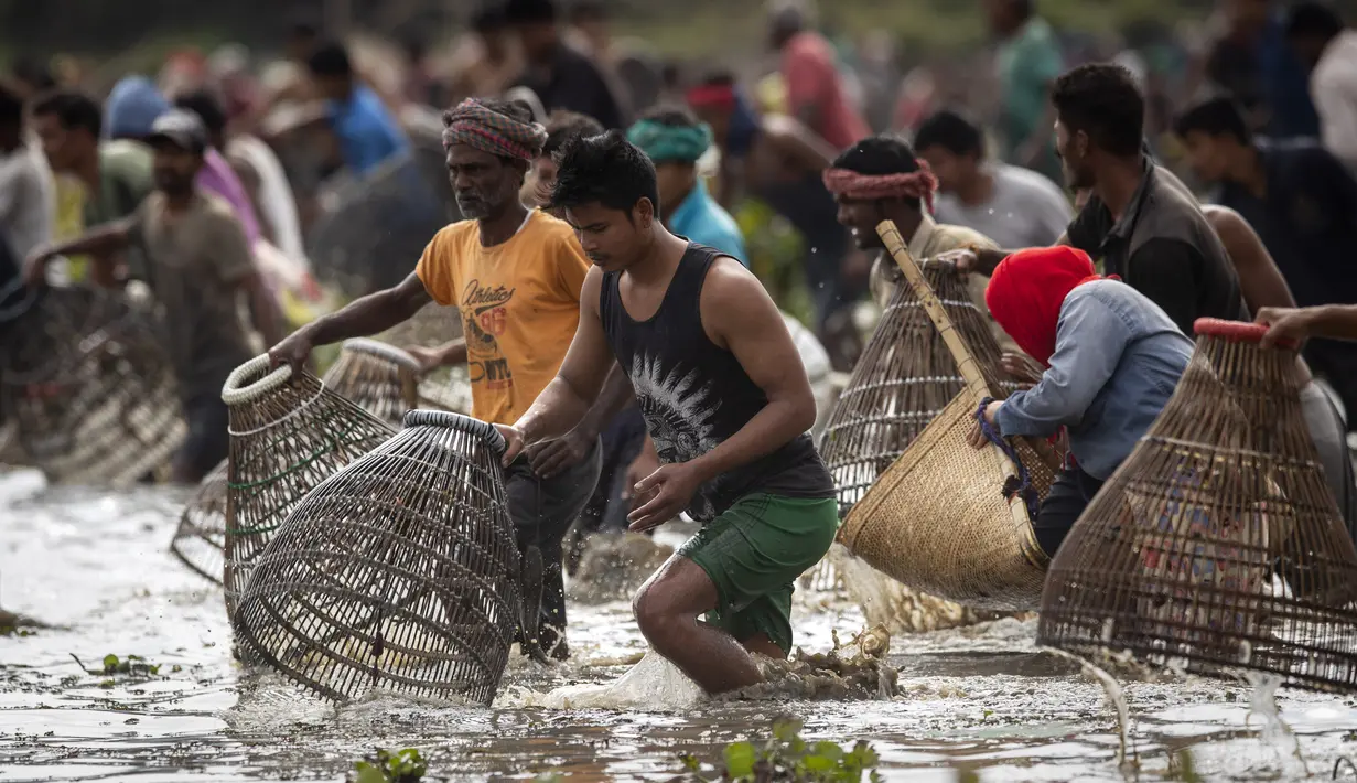 Penduduk desa berpartisipasi dalam komunitas memancing sebagai bagian dari perayaan Bhogali Bihu di desa Panbari, sekitar 50 km timur Gauhati, India, Kamis (13/1/2022). "Bhogali Bihu" menandai berakhirnya musim panen di timur laut negara bagian Assam. (AP Photo/Anupam Nath)