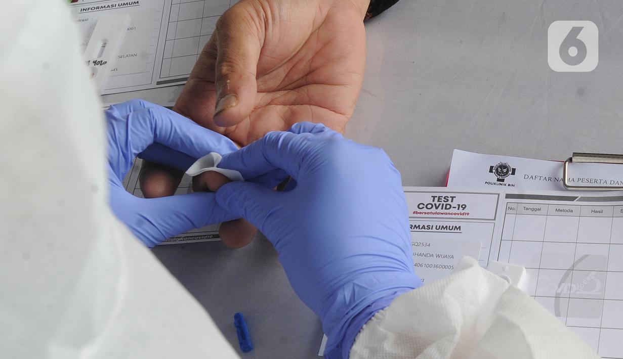 Petugas medis memeriksa warga saat rapid test oleh BIN di Lapangan Kantor Kecamatan Pamulang, Tangerang Selatan, Banten, Kamis (2/7/2020). BIN menggelar rapid test gratis terhadap 800 warga Pamulang untuk memutus mata rantai penyebaran virus corona COVID-19. (merdeka.com/Arie Basuki)