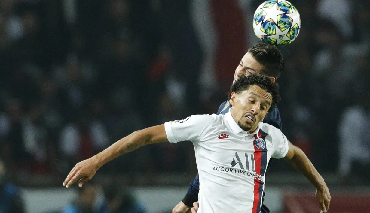 Bek Paris Saint-Germain (PSG), Marquinhos melompat saat berebut bola dengan gelandang Real Madrid, James Rodriguez dalam laga Grup A Liga Champions di Parc des Princes, Rabu (18/9/2019). PSG berhasil menaklukkan tamunya Real Madrid 3-0. (GEOFFROY VAN DER HASSELT / AFP)