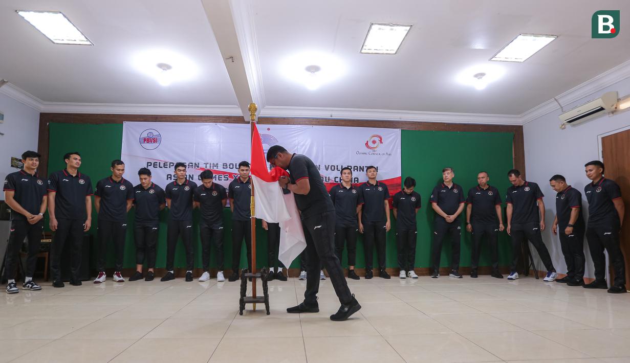 <p>Manajer Timnas Bola Voli Indoor Indonesia, Loudry Maspaitella (tengah) mencium bendera merah putih saat pelepasan Timnas Bola Voli Indonesia untuk Asian Games 2022 Hangzhou di Padepokan Voli Jenderal Kunarto, Sentul, Bogor, Kamis (14/09/2023). (Bola.com/Bagaskara Lazuardi)</p>