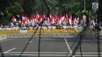 Massa aksi tertahan di belakang dua barikade yang dipasang pihak keamanan di Jalan Medan Merdeka Barat, Jakarta, Kamis (27/6/2019). Massa aksi berkumpul terkait pelaksanaan sidang putusan perselisihan hasil Pilpres 2019 di Gedung Mahkamah Konstitusi. (Liputan6.com/Helmi Fithriansyah)