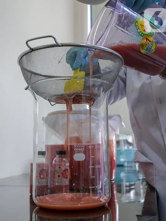 Peneliti menuangkan jambu merah yang telah diblender sebelum difermentasi di Kimia Pangan Pusat Penilitian Kimia LIPI Puspitek, Serpong, Tangerang, Kamis (4/6/2020). Fermentasi jambu memiliki kandungan polifenol, flavonoid, antioksidan dan asam organik. (Liputan6.com/Fery Pradolo)
