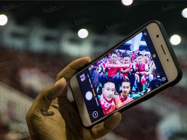 Suporter Timnas Indonesia selfie saat menonton laga semifinal Piala AFF 2016 melawan Vietnam di Stadion Pakansari, Jawa Barat, Sabtu (3/12/2016). (Bola.com/Vitalis Yogi Trisna)