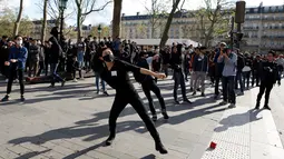 Sejumlah demonstran melempari petugas saat bentrokan terjadi di Place de la Republique, di Paris, Prancis (2/4). Mereka menggelar aksi terkait insiden pria China yang ditembak mati polisi, akhir Maret lalu. (AFP/Benjamin Cremel)