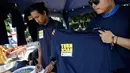 Penjual saat menjual baran dagangannya yang bertulisan "Turn Back Crime" saat Car Free Day kawasan Bunderan HI, Jakarta (13/3). Penggunaan merk 'Turn Back Crime' bertujuan untuk kampanye waspada tindak kejahatan. (Liputan6.com/Faizal Fanani)