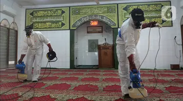 Petugas Dewan Masjid Indonesia (DMI) menyemprotkan cairan disinfektan di Masjid Hablul Muttaqin, Pejambon, Gambir, Jakarta Pusat, Jumat (6/3/2020). Kegiatan ini dilakukan untuk menjaga kebersihan masjid sekaligus mengantisipasi penyebaran virus corona (COVID-19). (Liputan6.com/Angga Yuniar)