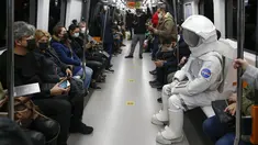 Seorang pria berpakaian astronaut naik metro sebagai bagian dari kampanye untuk mempromosikan Pameran Luar Angkasa NASA di Istanbul, Turki, pada 4 Desember 2021. Pameran ini akan menampilkan modul khusus dari luar angkasa dan puluhan instrumen berteknologi tinggi. (AP Photo/Emrah Gurel)
