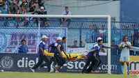 Kiper Persela Lamongan Choirul Huda dibawa oleh tim medis usai mengalami benturan dengan rekan setim, Ramon Rodrigues saat pertandingan Liga 1 di stadion Surajaya, Lamongan (15/10). (AFP Photo/Juni Kriswanto)