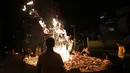 Makanan persembahan dan uang kertas serta dupa dibakar untuk menjaga roh-roh nenek moyang mati bahagia dan membawa keberuntungan, Kuala Lumpur, (3/8/2014). (REUTERS/Olivia Harris)