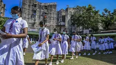 Para siswi kelompok usia 12-15 tahun mengantre untuk mendapatkan suntikan vaksin Pfizer-BioNTech terhadap virus corona Covid-19 di sebuah lembaga pendidikan di Kolombo, Sri Lanka (7/1/2022). (AFP/Ishara S. Kodikara)