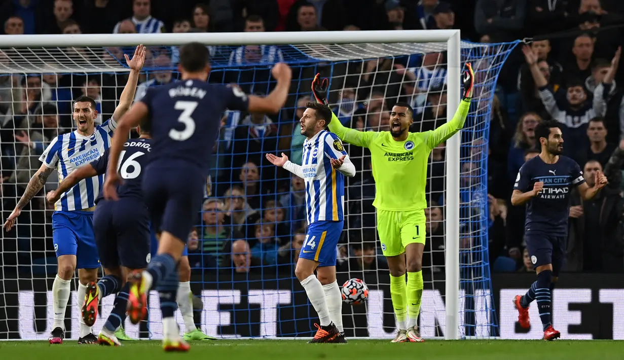 Manchester City sudah unggul 1-0 pada menit ke-13. Sepakan Ilkay Guendogan (kanan) usai meneruskan bola liar dari Bernardo Silva tidak mampu dihalau kiper Brighton, Robert Sanchez. (AFP/Glyn Kirk)