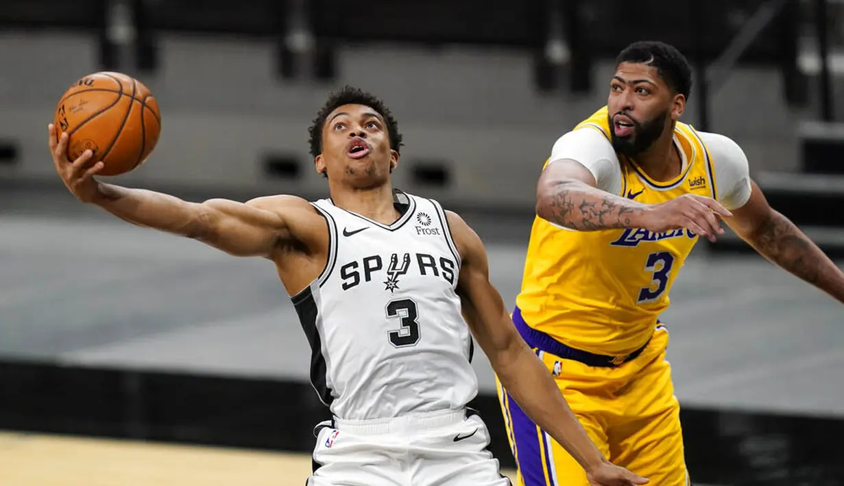 Pebasket Los Angeles Lakers, Anthony Davis, berebut bola dengan pebasket San Antonio Spurs, Keldon Johnson, pada laga NBA di AT&T Center, Kamis (31/12/2020). LA Lakers menang dengan skor 121-107. (AP/Eric Gay)