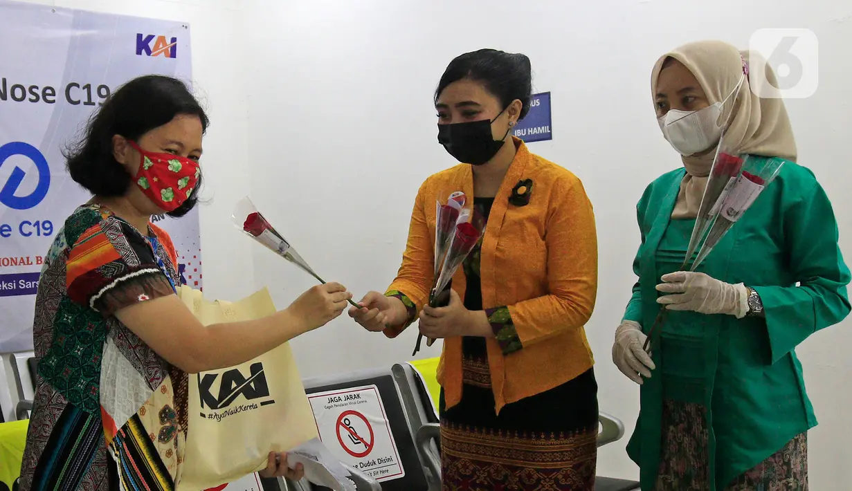Petugas PT KAI Daop 1 Jakarta berkebaya membagikan bunga kepada penumpang di Stasiun Gambir, Rabu (21/4/2021). PT KAI DAOP 1 memperingati Hari Kartini menginspirasi para penumpang agar semangat berjuang melawan pandemi COVID-19 dengan selalu menerapkan protokol kesehatan. (Liputan6.com/Herman Zakhar