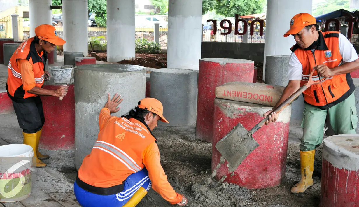 Petugas PPSU melakukan penambalan di tempat duduk beton di taman Interaktif FO Klender, Jakarta, Rabu (10/2). Pihak Kecamatan Pulogadung dan Kelurahan Jatinegara mulai perbaiki fasilitas taman sebelumnya rusak parah. (Liputan6.com/Yoppy Renato)