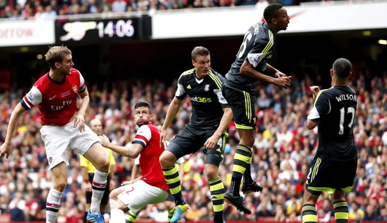 Per Mertesacker duel udara dengan pemain Stoke City pada pertandingan Liga Premier Inggris antara Arsenal vs Stoke City di Stadion Emirates, London (22/09/2013). (AFP/Adrian Dennis)