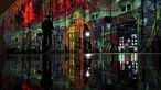 Orang-orang melewati pertunjukan cahaya malam di Lyon, Prancis tengah, Rabu (8/12/2021). Jutaan orang diperkirakan akan menghadiri acara Festival of Lights selama empat hari di kota itu. (AP Photo/Laurent Cipriani)