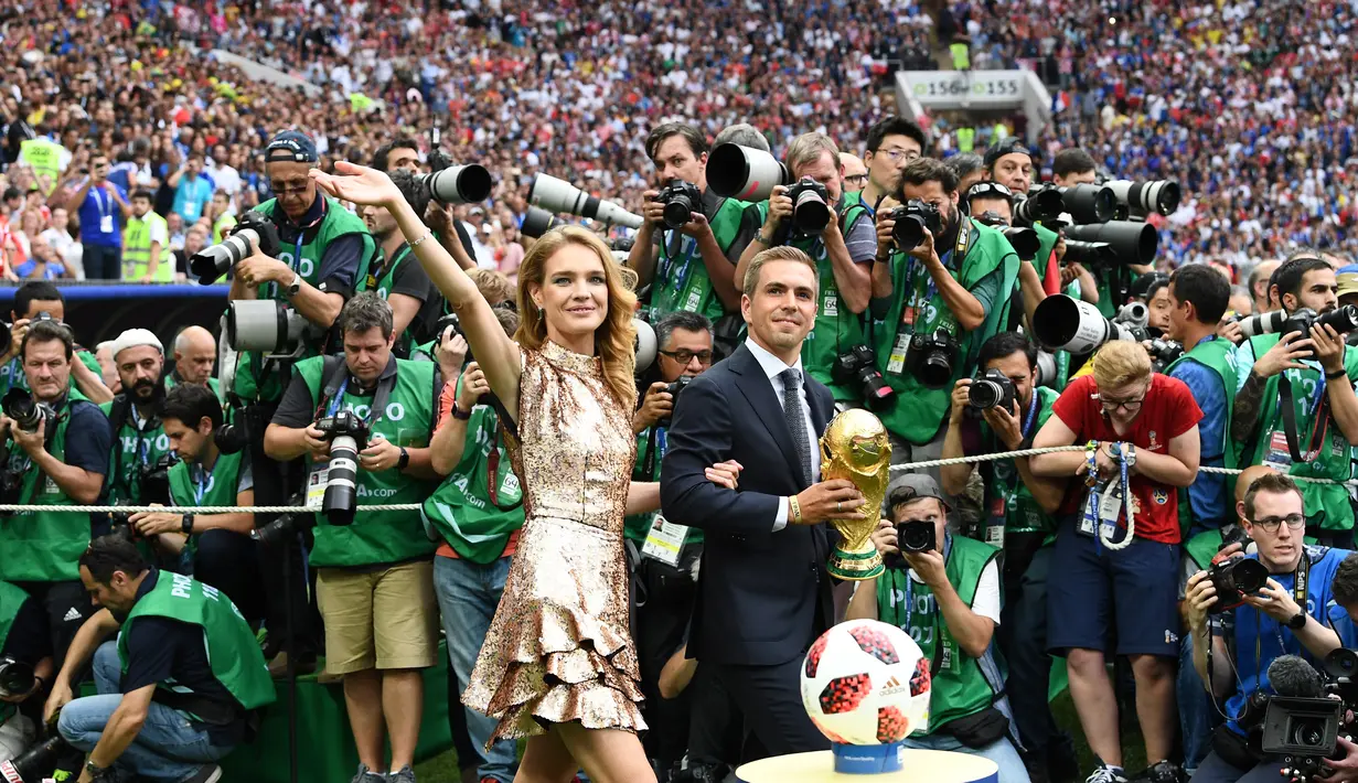 Mantan kapten Jerman Philipp Lahm (kanan) dan model Rusia Natalia Vodianova (kiri) menyapa penonton dengan membawa trofi Piala Dunia pada penutupan Piala Dunia 2018 Rusia di Stadion Luzhniki, Moskow (15/7). (AFP Photo / Franck Fife)