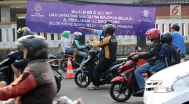 Spanduk sosialisasi uji coba pengalihan arus lalu lintas terpampang di pertigaan Jalan Pramuka Sari II, Tambak dan Proklamasi, Jakarta, Jumat (21/7). Pengalihan arus lalu lintas terkait pembangunan underpass Matraman. (Liputan6.com/Helmi Fithriansyah)