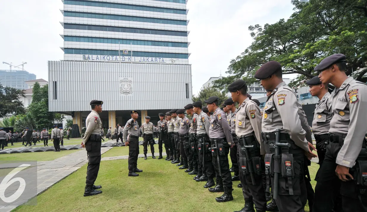 Pasukan polisi berbaris saat upacara di halaman Balai Kota, Jakarta, Jumat (4/11). Sejak pukul 07.00 WIB terlihat personel kepolisian yang sudah melakukan apel untuk pengamanan unjuk rasa 4 November. (Liputan6.com/Yoppy Renato)