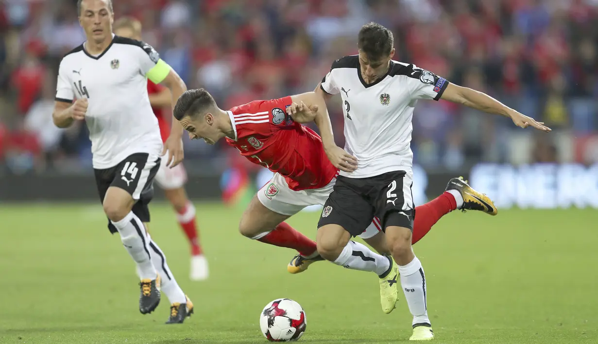 Pemain Wales, Tom Lawrence (tengah) mencoba melewati adangan pemain Austria, Stefan Lainer pada laga Group D kualifikasi Piala Dunia 2018 di Cardiff City Stadium, Cardiff, (2/8/2017). Wales menang 1-0. (David Davies/PA via AP)