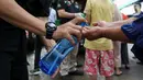Warga membersihkan tangan menggunakan hand sanitizer saat antre Operasi Pasar di Pasar Palmerah, Jakarta, Jumat (20/3/2020). Di tengah merebaknya virus corona Perum Bulog menggelar Operasi Pasar untuk mencegah panic buying dengan harga murah. (Liputan6.com/Fery Pradolo)