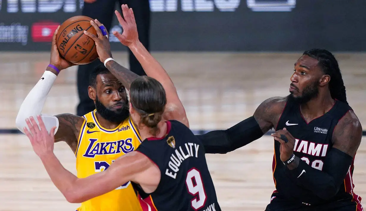 Pebasket Los Angeles Lakers, LeBron James, berusaha melewati pebasket Miami Heat pada gim pertama final NBA di Lake Buena Vista, Kamis (1/10/2020). Lakers menang dengan skor 116-98. (AP Photo/Mark J. Terrill)