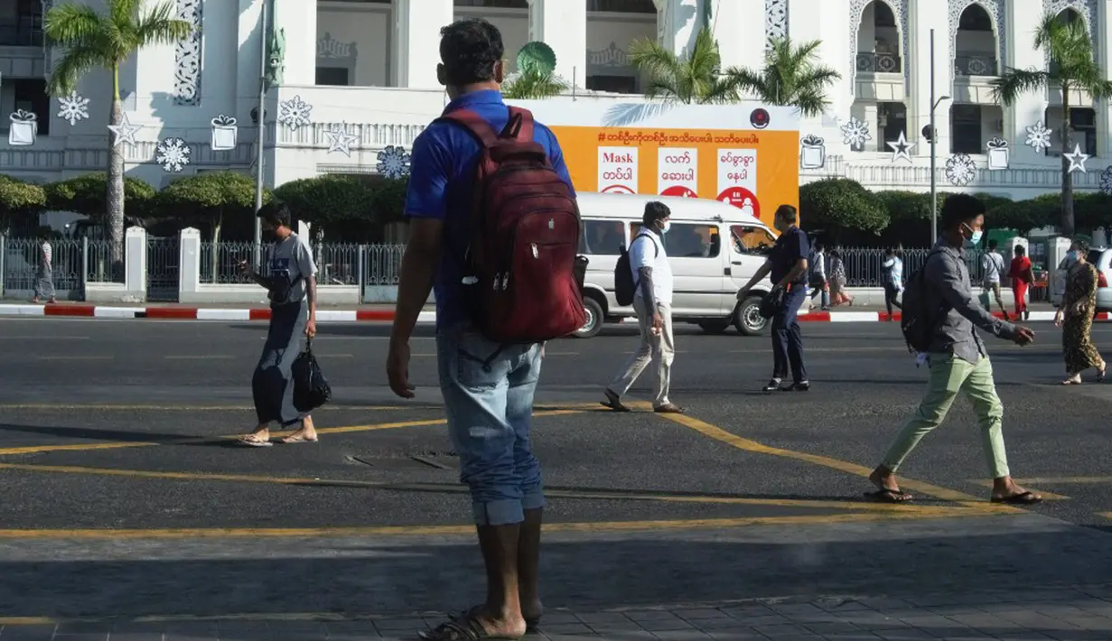 Orang-orang berjalan melewati Balai Kota sehari setelah militer Myanmar merebut kekuasaan, Yangon, Myanmar, Selasa (2/2/2021). Militer Myanmar menahan pemimpin yang terpilih secara demokratis Aung San Suu Kyi dan memberlakukan keadaan darurat satu tahun. (STR/AFP)