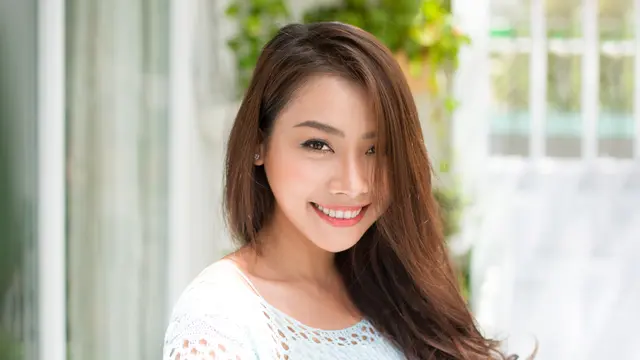 perempuan cantik tersenyum santai di rumah