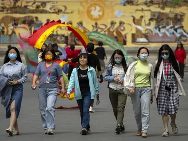 Orang-orang yang memakai masker berjalan di taman umum di Beijing, Kamis (21/4/2022). Di daratan Cina, jumlah kematian meningkat menjadi lebih dari 20 dalam wabah di Shanghai yang menutup kota terbesar di negara itu. (AP Photo/Mark Schiefelbein)