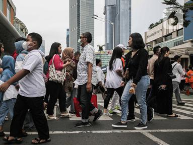Warga berjalan di pedestrian kawasan Bundaran Hotel Indonesia (HI), Jakarta, Sabtu (30/12/2023). (Liputan6.com/Faizal Fanani)