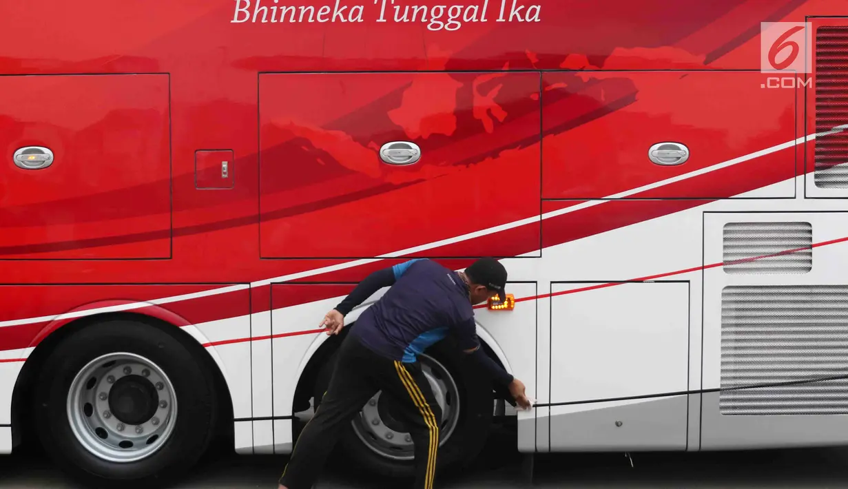 Petugas membersihkan bus transjakarta yang akan digunakan untuk pawai kemenangan tim sepak bola Persija Jakarta di kantor PT Transjakarta, Cawang, Kamis (13/12). Bus tersebut akan digunakan untuk pawai kemenangan Persija. (Liputan6.com/Immanuel Antonius)