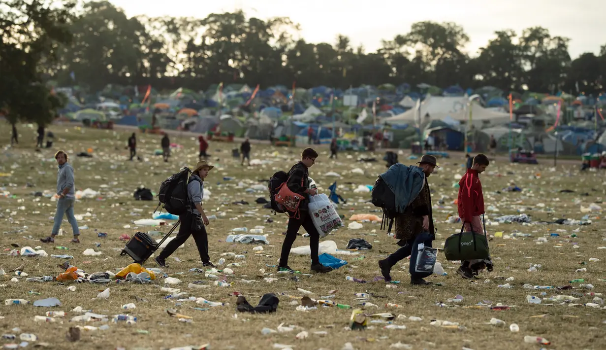 Para pengunjung bersiap meninggalkan lokasi pada akhir Festival Glastonbury di arena Worthy Farm, Inggris, 26 Juni 2017. Penyelenggaraan festival musik terbesar di dunia itu menyisakan sampah yang berserakan di seluruh arena. (OLI SCARFF/AFP)