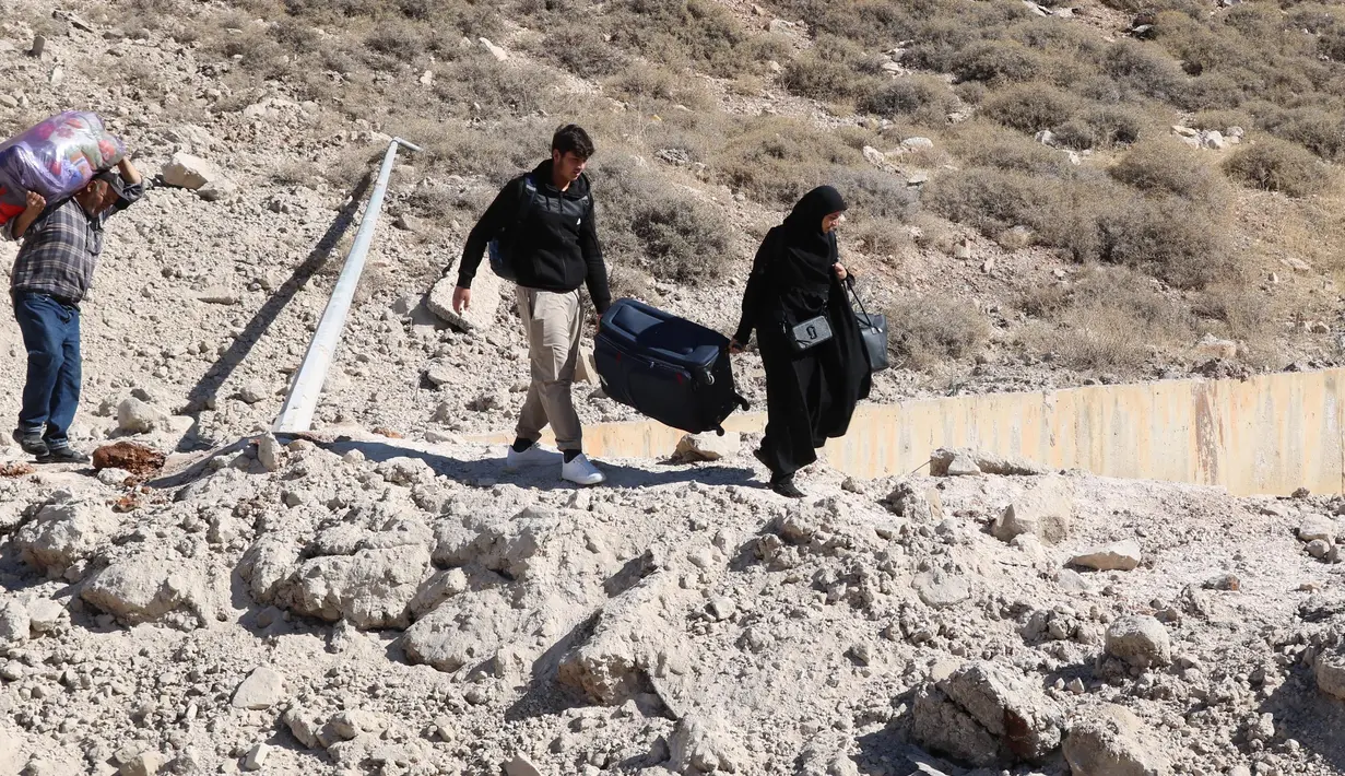 Serangan Israel di dekat wilayah lintas batas Lebanon-Suriah menimbulkan lubang selebar 4 meter dan membuat jalan terputus. (HASSAN JARRAH/AFP)