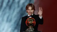 Gelandang Real Madrid, Luka Modric melambaikan tangan sambil memegang penghargaan Ballon d'Or 2018 di Grand Palais, Paris, Senin (3/12). Modric sukses memutus dominasi Cristiano Ronaldo dan Lionel Messi yang bertahan selama satu dekade (AP/Christophe Ena)