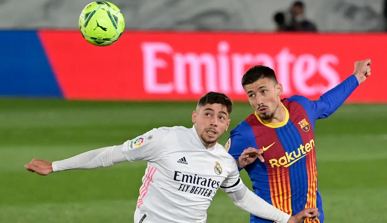Gelandang Real Madrid, Federico Valverde (kiri) dan bek Barcelona, Clement Lenglet melompat untuk berebut pada pekan ke-30 Liga Spanyol di Estadio Alfredo Di Stefano, Minggu dinihari WIB (11/4/2021). Real Madrid kembali sukses taklukkan rival abadinya Barcelona 2-1.  (JAVIER SORIANO / AFP)