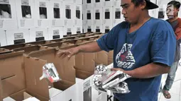 Pekerja memasukkan paket alat tulis untuk mencoblos ke dalam kotak suara Pemilu 2019 di Gudang Logistik KPU Kota Bekasi, Jawa Barat, Rabu (20/12). (Merdeka.com/Iqbal S. Nugroho)