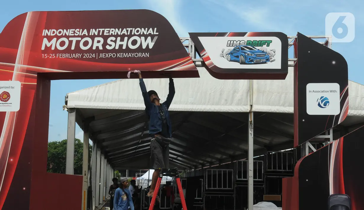 Pekerja menyelesaikan pembuatan stand pameran Indonesia International Motor Show 2024 di Jakarta International Expo (JIexpo), Jakarta Senin (12/2/2024). (merdeka.com/Imam Buhori)