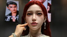 Seorang wanita menyentuh wajah robot humanoid selama peluncuran robot humanoid U1 yang diproduksi oleh UWORLD, sebuah merek di bawah UBTECH Robotics, di Shenzhen, provinsi Guangdong, Tiongkok, Selasa (30/06/2026). (AFP/ Adek Berry)