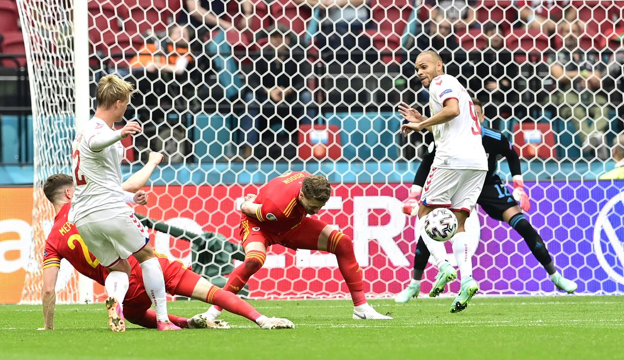 Banyak ditekan, Denmark justru mencetak gol pertamanya pada menit ke-27. Kerjasama bek Joakim Maehle dengan Kasper Dolberg mampu diselesaikan dengan tendangan terukur dari luar kotak penalti oleh Kasper Dolberg. Denmark unggul 1-0. (Foto: AP/Pool/Olaf Kraak)