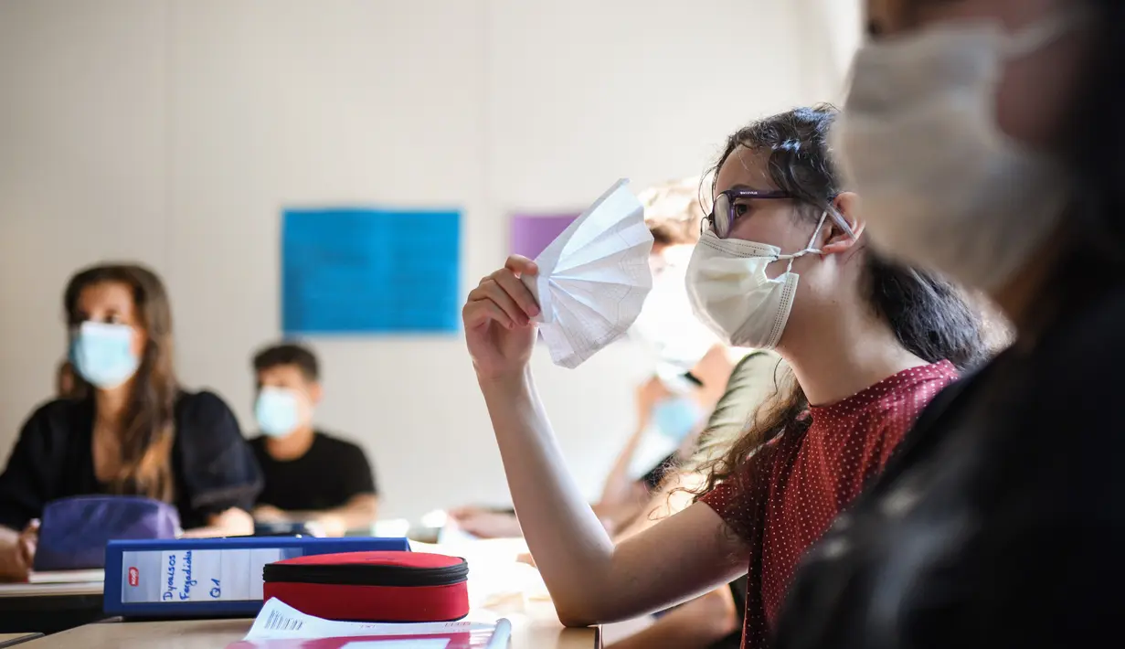 Siswa kelas sebelas dengan masker duduk di ruang kelas sekolah menengah Phoenix di Dortmund, Jerman barat, Rabu (12/8/2020). Para siswa di negara bagian Jerman, North Rhine-Westphalia, harus mengenakan masker setiap waktu ketika mereka kembali ke sekolah pada Rabu ini. (Ina FASSBENDER/AFP)