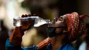 Pekerja meminum air dari botol di tengah meningkatnya suhu di New Delhi, India, Rabu (27/5/2020). India dilanda gelombang panas dan krisis air bersih di tengah upaya menangani pandemi virus corona COVID-19. (Jewel SAMAD/AFP)