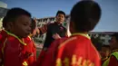 Mantan penyerang Manchester United, Dong Fangzhuo berbicara dengan anak-anak saat melatih di Xiamen di provinsi Fujian, China (10/12/2019). Dong Fangzhuo yang kini berusia 34 tahun melatih anak-anak di China, beberapa di antaranya berkebutuhan khusus. (AFP/Hector Retamal)