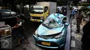 Satu unit taksi ringsek tertimpa pohon tumbang di Jalan Taman Kebon Sirih, Jakarta, Selasa (30/8). Pohon yang batangnya besar tersebut tumbang akibat hujan deras disertai angin kencang yang melanda Jakarta tadi siang. (Liputan6.com/Faizal Fanani) 