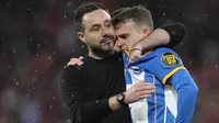 Pelatih kepala Brighton, Roberto De Zerbi (kiri) memberikan pelukan kepada pemainnya, Solly March setelah gagal mengeksekusi tendangan penalti pada laga semifinal Piala FA 2022/2023 di Stadion Wembley, London, Minggu (23/04/2023). Laga dimenangkan oleh MU dengan skor 7-6. (AP Photo/Kirsty Wigglesworth)