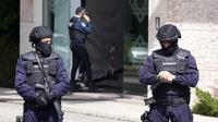 Polisi berdiri di pintu masuk Muslim Ismaili Center di Lisbon, Portugal, di mana seorang penyerang menikam dua orang dengan fatal pada Selasa (28/3/2023). (Armando Franca / Associated Press)