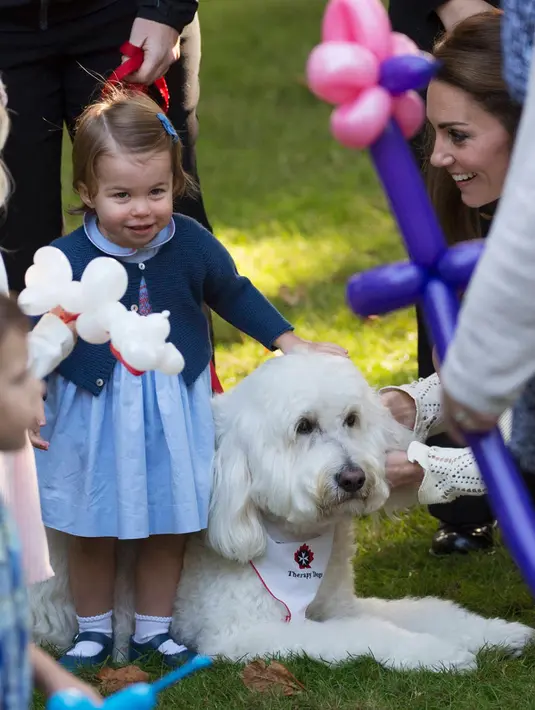 Putri Charlotte berpose dengan anjing besar ditemani ibunya, Kate Middleton saat menghadiri pesta anak-anak di Government House di Victoria, British Columbia, Kanada, (29/9). (REUTERS/Chris Wattie)