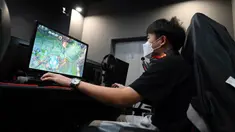 Seorang pria bermain game komputer di sebuah kafe internet di Beijing, China, Jumat (10/9/2021). Pejabat China memanggil perusahaan game, termasuk dua yang terbesar yaitu Tencent dan NetEase, untuk membahas pembatasan lebih lanjut pada industri game online. (GREG BAKER/AFP)