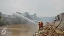 Petugas pemadam kebakaran mengarahkan selang air ke arah titik api yang membakar pemukiman padat penduduk di Kelurahan Bukit Duri RT 05 RW 12, Jakarta, Selasa (23/2). Sebanyak 20 mobil pemadam diturunkan. (Liputan6.com/Gempur M Surya)