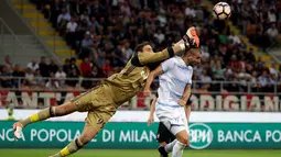 Kiper AC Milan, Gianluigi Donnarumma berusaha menghalau bola sundulan penyerang Lazio, Filip Djordjevic pada liga Italia di stadion San Siro, Milan, Italia, (21/9). AC Milan menang atas Lazio dengan skor 2-0. (REUTERS/Max Rossi)