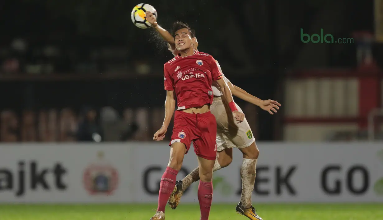 Rezaldi Hehanussa menghalau bola dari kejaran pemain Persebaya, Rishadi Fauzi pada laga Gojek Liag 1 bersama Bukalapak di Stadion PTIK, Jakarta (26/6/2018). Persija dan Persebaya bermain imbang 1-1. (Bola.com/Nick Hanoatubun)